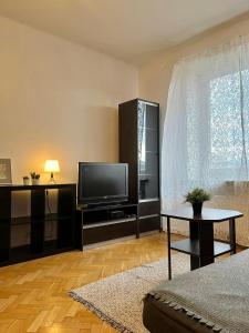 un soggiorno con TV e tavolo di Old Town Apartment a Cracovia