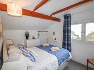 a bedroom with a bed and a window at Little Ruffo in Tintagel