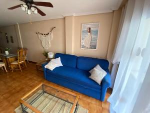 um sofá azul numa sala de estar com uma mesa de vidro em Vive Rie Ama Tenerife - 2 bedroom apartment em San Miguel de Abona
