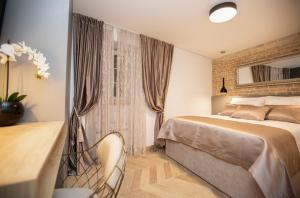 um quarto com uma cama e uma cadeira em Luxury Apartments Lilly 2 em Split