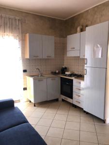 a kitchen with white cabinets and a white refrigerator at APPARTAMENTO Tamburro in Campobasso