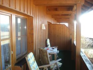 eine kleine Veranda mit einem Tisch und Stühlen in einer Hütte in der Unterkunft Ferienwohnung für 2 Personen ca 41 m in Rinchnach-Hönigsgrub, Bayern Bayerischer Wald in Rinchnach