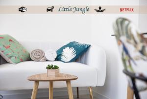 stolik kawowy przed białą kanapą z poduszkami w obiekcie Little Jungle - T2 avec parking w mieście Vierzon
