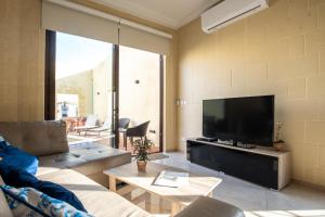 een woonkamer met een grote televisie en een bank bij Narcisa - Luxury 3BR Traditional House with Pool, Cinema & Hot Tub in Tal-Barmil