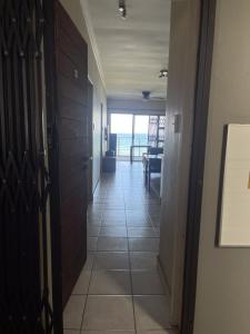 a hallway with a door and a view of the ocean at Beach Escape on the coast at apartment 78 Sancta Maria in Amanzimtoti