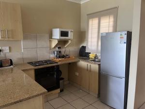 a kitchen with a white refrigerator and a microwave at Beach Escape on the coast at apartment 78 Sancta Maria in Amanzimtoti