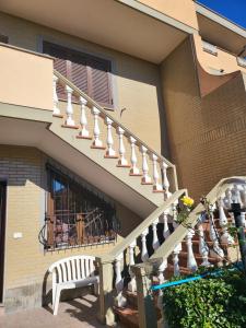 una casa con una escalera y un banco frente a una ventana en Fiumicino River, en Fiumicino