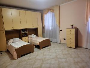 a bedroom with two beds and a dresser and a window at Fiumicino River in Fiumicino +5 photos