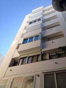 リョレート・デ・マルにあるLinda Appartamento Lloretの高い白いアパートメントビル(窓付)