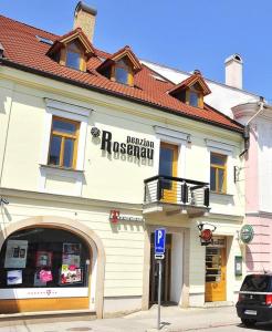 een gebouw met een bord aan de voorkant bij Penzión Rosenau in Rožňava