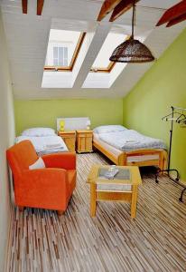 ロジュニャバにあるPenzión Rosenauのベッド2台、ソファ、テーブルが備わる客室です。
