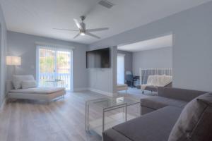 a living room with a couch and a ceiling fan at Once Upon A Tide Oceanview Condo Pet Friendly in Jacksonville Beach