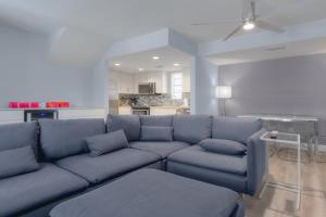 sala de estar con sofá azul y cocina en Once Upon A Tide Oceanview Condo Pet Friendly en Jacksonville Beach