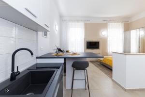 cocina con fregadero y encimera con taburete en Apartments & Rooms Kolovare Beach, en Zadar