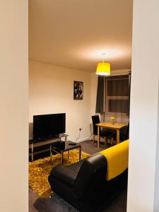 a living room with a couch and a television at City Blessed Apartment 1 with free parking in North Shields