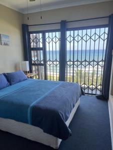 a bedroom with a bed and a view of the ocean at Beach Escape on the coast at apartment 78 Sancta Maria in Amanzimtoti