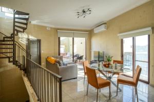 een woonkamer met een tafel en een bank bij Narcisa - Luxury 3BR Traditional House with Pool, Cinema & Hot Tub in Tal-Barmil