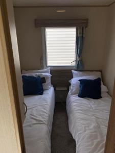 two beds in a small room with a window at Withersea Sand Holiday Home in Withernsea