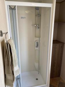 a shower with a glass door in a bathroom at Withersea Sand Holiday Home in Withernsea
