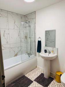 uma casa de banho com uma banheira, um lavatório e um chuveiro em City Blessed Apartment 1 with free parking em North Shields