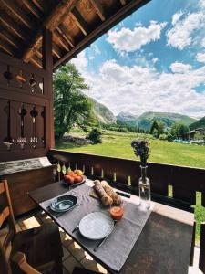 a table with plates of food and a view of mountains at VAL D'ISERE - 2 Bedroom Apartment & Private Parking in La Daille