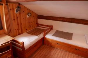 two twin beds in a room with wooden walls at VAL D'ISERE - 2 Bedroom Apartment & Private Parking in La Daille