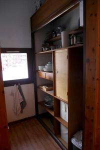 uma cozinha com prateleiras de madeira com pratos e uma janela em VAL D'ISERE - 2 Bedroom Apartment & Private Parking em La Daille