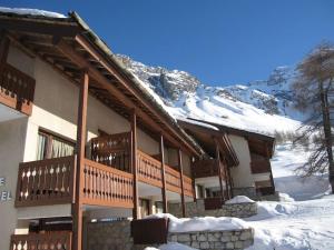 a building in the snow with snow covered mountains at VAL D'ISERE - 2 Bedroom Apartment & Private Parking in La Daille
