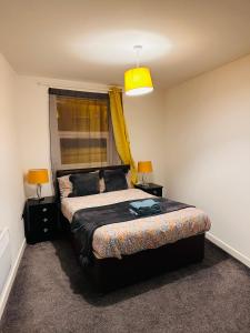 a bedroom with a bed and a yellow light at City Blessed Apartment 1 with free parking in North Shields
