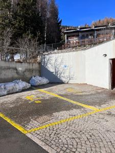 a parking lot next to a wall with snow at Elegante e moderno monolocale in Oga