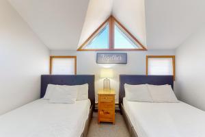 Dos camas individuales en una habitación con ventana. en Chateau Ridge 223, en Blue Mountains