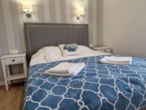 um quarto com uma cama azul e branca com toalhas em HoliApart in Nautikka Park em Krynica Morska