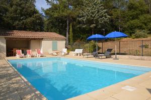 basen z 2 niebieskimi parasolami i krzesłami w obiekcie Belle villa piscine Provence Uzes climatisée w mieście Saint-Victor-des-Oules