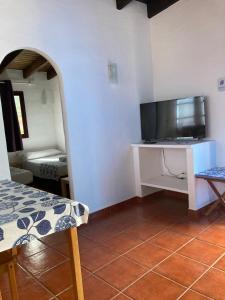 een kamer met een tv en een tafel met een televisie bij Apartamentos y Habitaciones Villa Marina in La Caleta