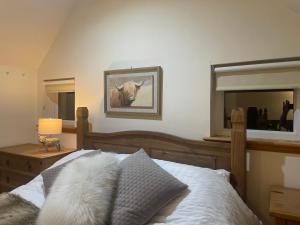 a bedroom with a bed and a mirror at Cleadale flat in Breakish