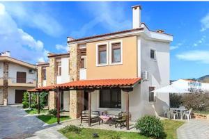 a house with a patio with a table and chairs at Villa Armonia in Skala Potamias