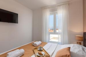 a bedroom with a bed with a tray of food on it at Apartments Cesare in Nin