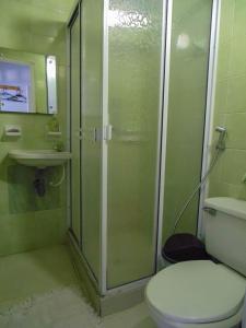 ein Bad mit einer Dusche, einem WC und einem Waschbecken in der Unterkunft Hotel Ciudad Señora Buga in Buga