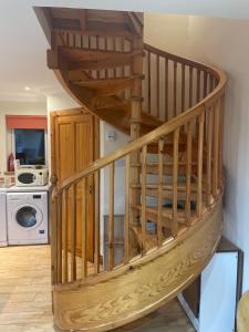 a wooden spiral staircase in a living room at Cleadale flat in Breakish