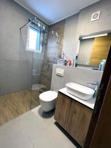 La salle de bains est pourvue de toilettes, d'un lavabo et d'une douche. dans l'établissement Apartman LENA, à Bjelašnica