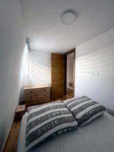 - une chambre avec un lit, une commode et une porte dans l'établissement Apartman LENA, à Bjelašnica