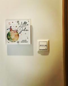 obraz wiszący na ścianie z włącznikiem światła w obiekcie Little John Luxury Apartment w Pireusie