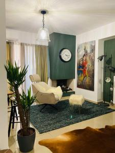 a living room with a chair and a clock on the wall at Little John Luxury Apartment in Piraeus