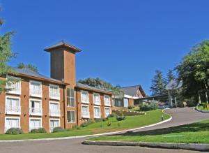a large brick building with a tower on top of it at Howard Johnson Hotel & Spa Villa General Belgrano in Villa General Belgrano