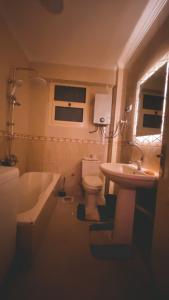 La salle de bains est pourvue d'une baignoire, de toilettes et d'un lavabo. dans l'établissement Restful and trendy apartment in 6 October city Cairo, à Ville du 6 Octobre