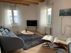 - un salon avec un canapé et une télévision dans l'établissement Señorial Panorámico by Exclusive Burgos Apartments, à Burgos