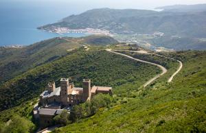 a castle on top of a hill with a road at La Casita in Pau