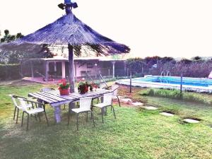 - une table avec des chaises, un parasol et une piscine dans l'établissement FINCA EL CAMPITO, piscina, bbq, ping-pong, billar, 10 min andando de la playa, à Rota