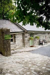 a stone building with a bench in front of it at Carleys Cottage in Fanore