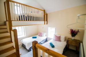 two beds in a room with a staircase at Carleys Cottage in Fanore